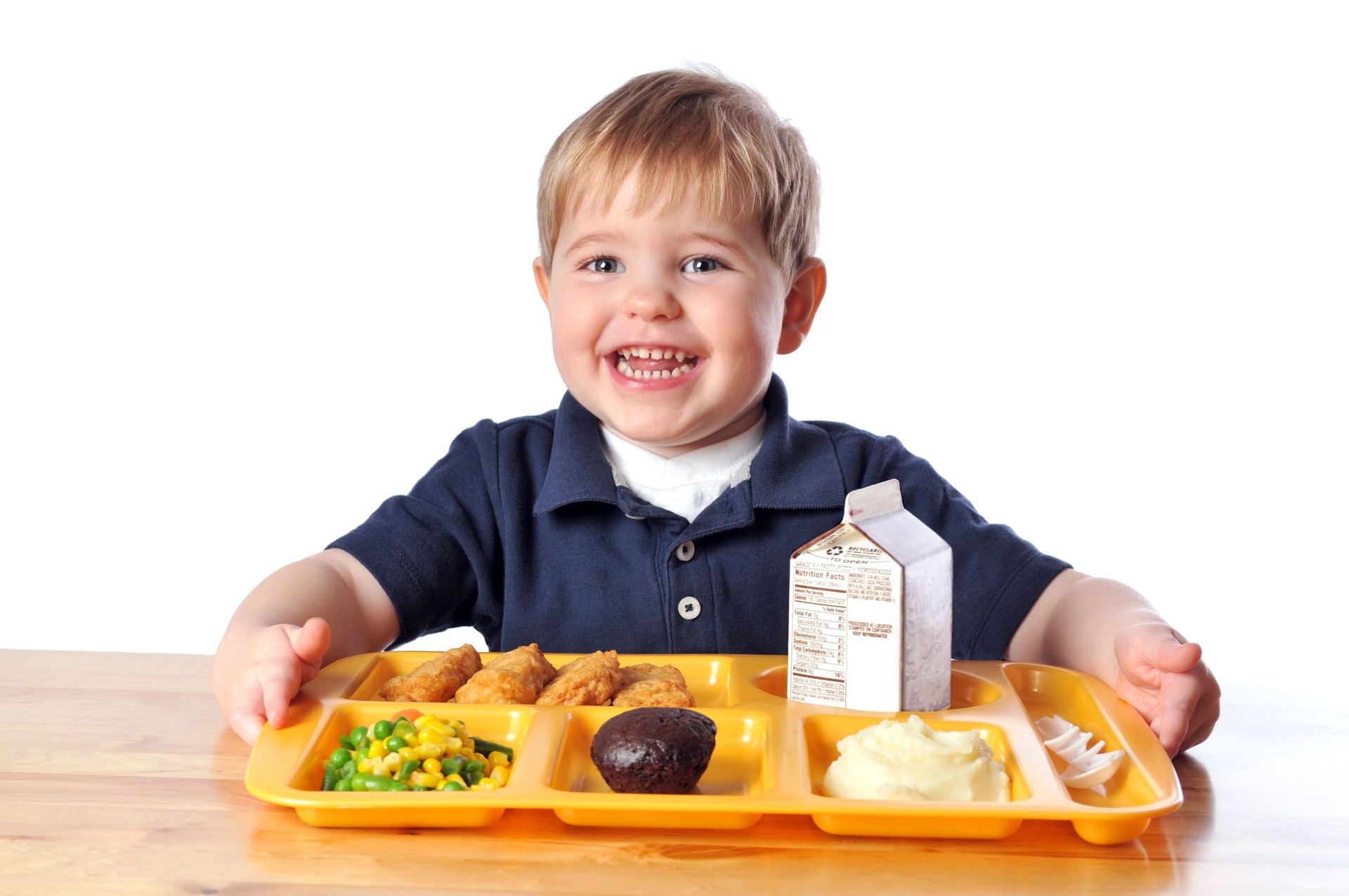 Young Boy Sitting at a Table with his School Lunch